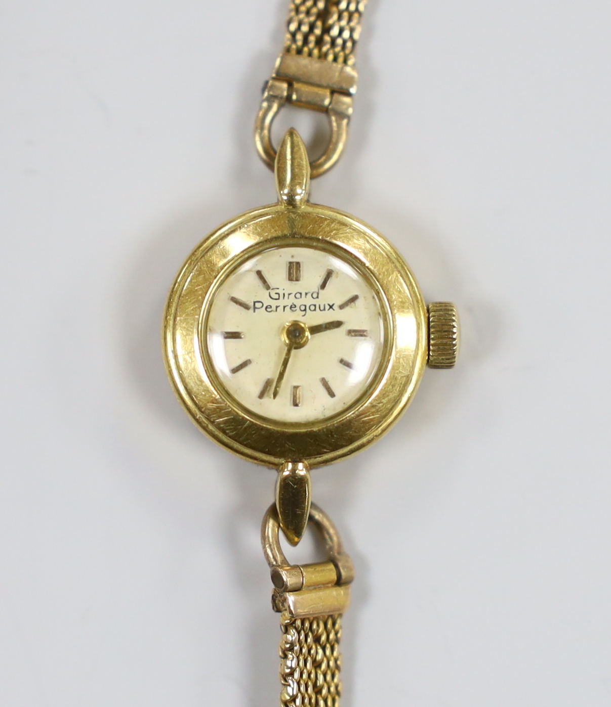 A lady's yellow metal Girard Perregaux manual wind wrist watch, on a 9ct twin strand bracelet, gross weight 12.6 grams, with Girard Perregaux box.